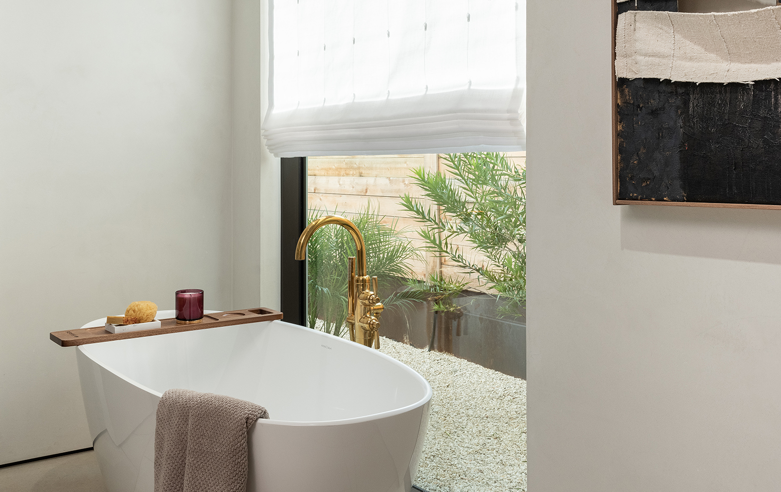 Light-filtering roman shades over a serene bath full of natural light in the daytime
