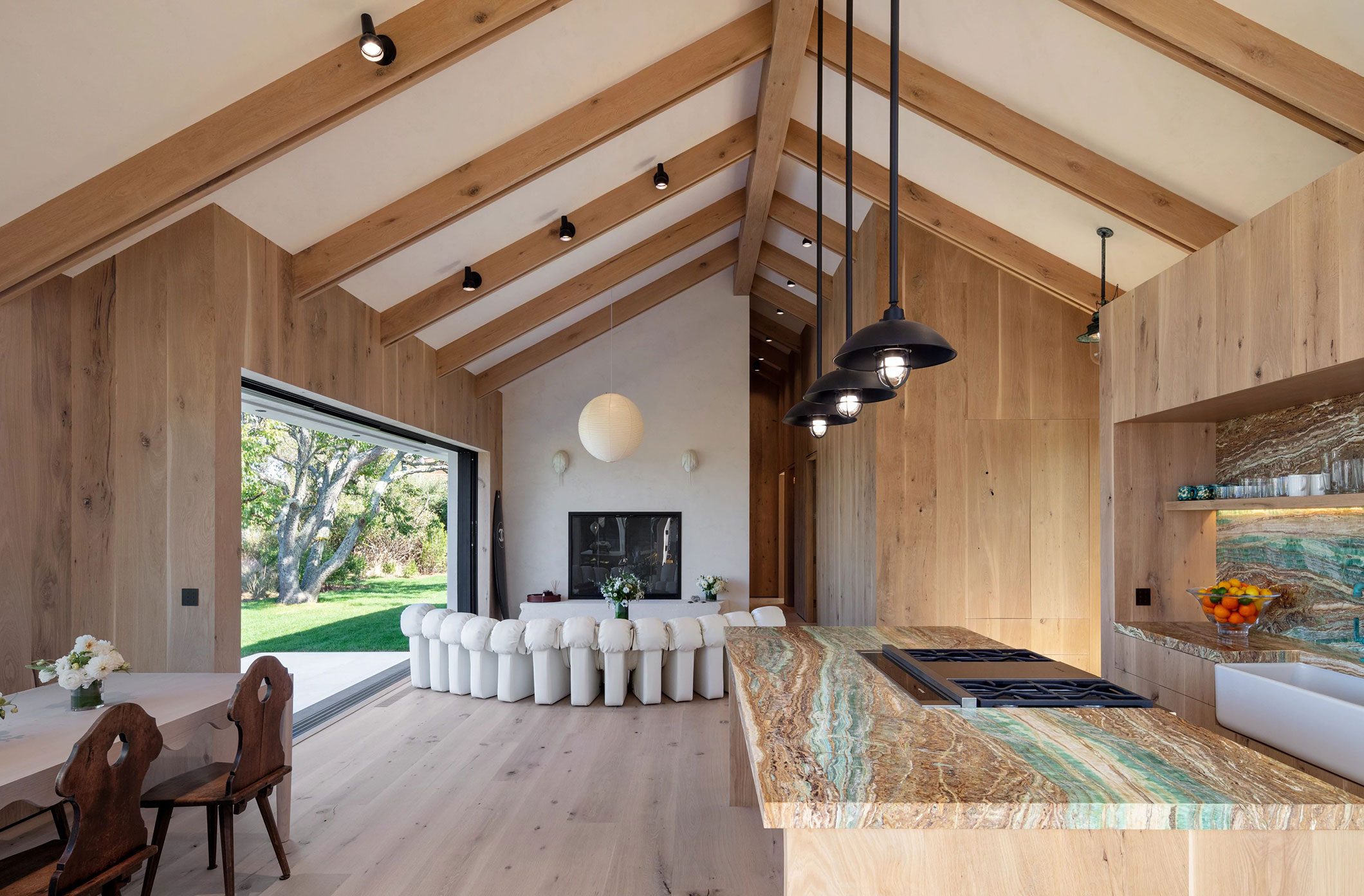 A barn house showing ambient lighting layer through natural daylight and task lighting layer with pendants