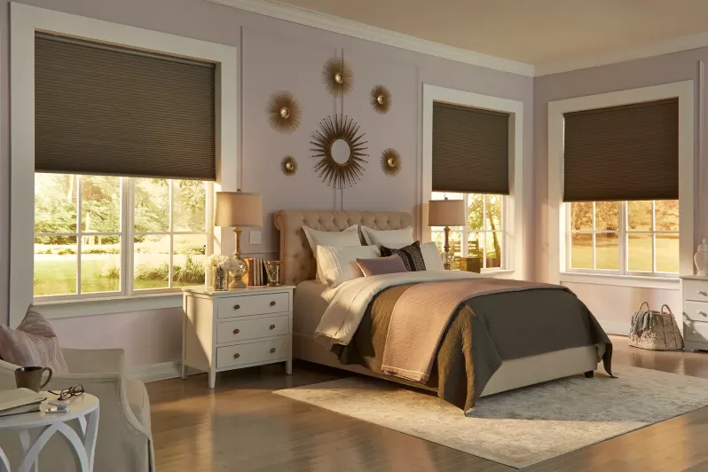 Automated cellular shades in bedroom setting provide privacy while minimizing daylight through room-darkening fabrics