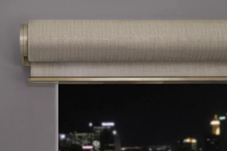 Automated roller shades raised to almost disappear above the window.