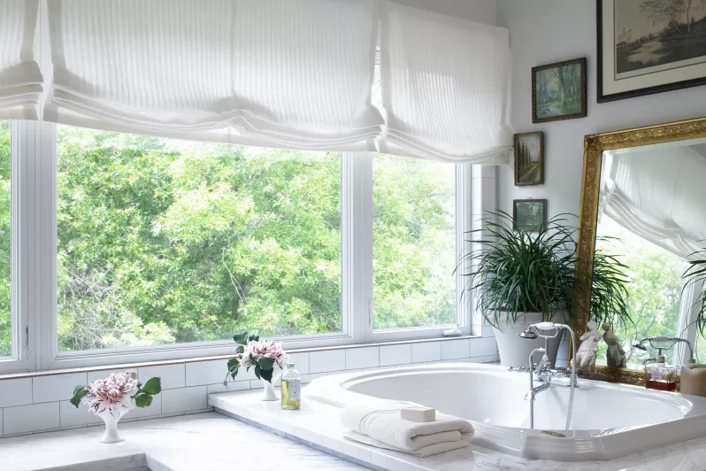 Roman shades in light-filtering fabric to baclance privacy and natural light in bathroom