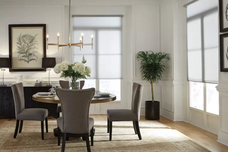 Dining room with roller shades in a light fabric