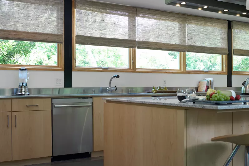 Roman shades with intelligent hembar alignment balance views and daylight control in kitchen